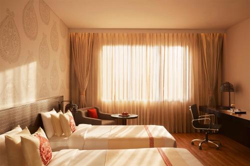 a hotel room with two beds and a window at Vivanta Guwahati in Guwahati