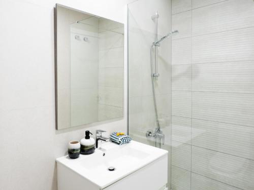 a white bathroom with a sink and a shower at Apartment Abora Garden with terrace, pool, extensive gardens and free parking in Las Palmas de Gran Canaria