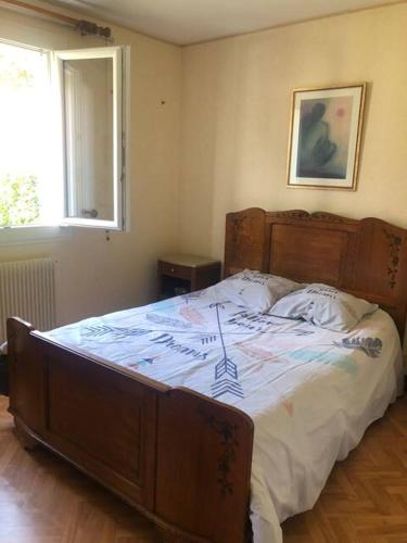 maison d evacances في لو بورغ: غرفة نوم بها سرير ذو إطار خشبي