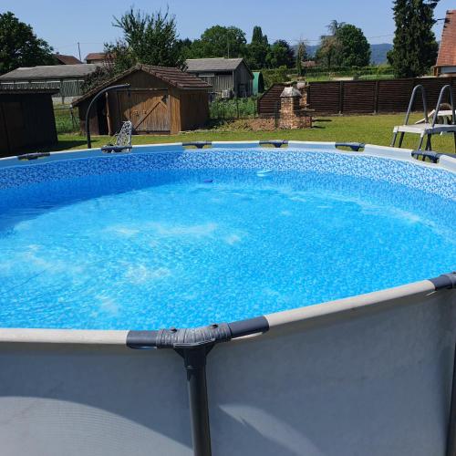 une grande piscine d'eau bleue dans un jardin dans l'établissement Villa porte bonheur, à Arenthon