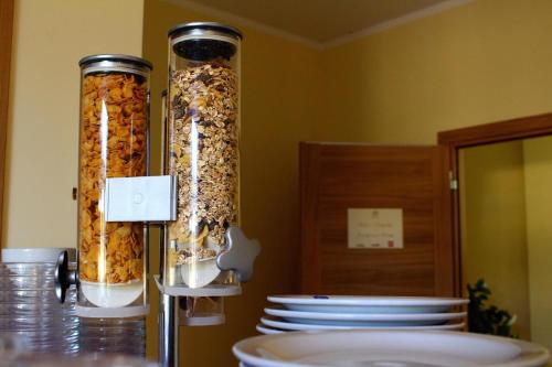two tall containers of food sitting on a table with plates at B&B Marzia in Cuneo