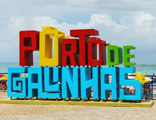 a large sign for a beach with the words paradise grille at Flat Brisa do Mar - Centro Porto - 300 metros das piscinas naturais in Porto De Galinhas
