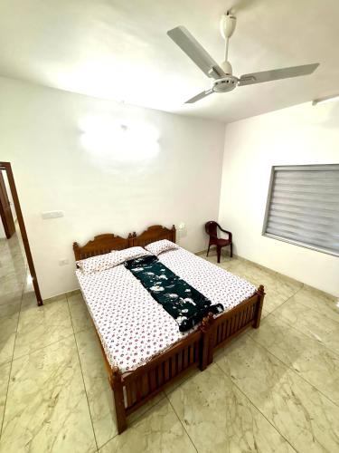 a bed in a room with a ceiling fan at Pavans Rainy Days Home Stay in Athirappilly