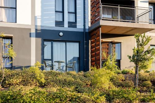 a house with a balcony with a table and chairs at Chawal Stays Green Valley 1 in Nelspruit