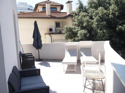 a patio with chairs and a table and an umbrella at Hotel Vienna in Pesaro