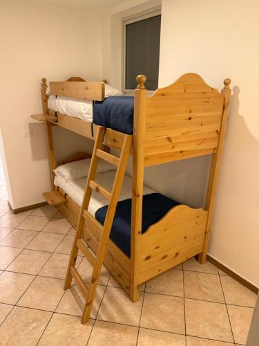 a wooden bunk bed with a ladder in a room at Villa Pinewood in Lignano Sabbiadoro