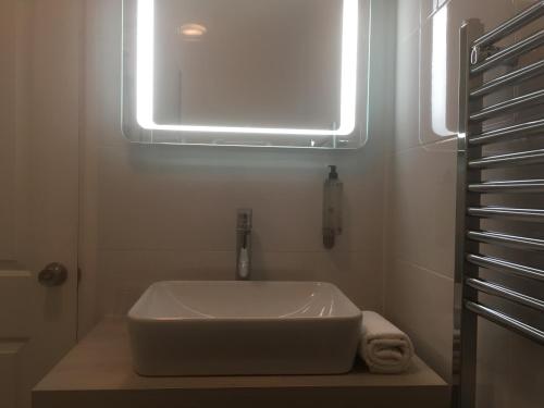 a white sink in a bathroom with a window at Portreath Arms in Portreath