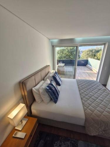 a bedroom with a bed with a view of a balcony at Espinho Charm Stay in Espinho