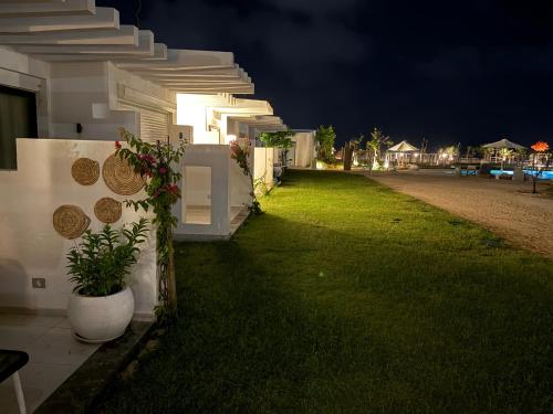 a house with a green lawn next to a building at North coast Cozy cabin Seaview & Lagon in D-bay I Beach Access Included in Zāwiyat ‘Abd al Mun‘im