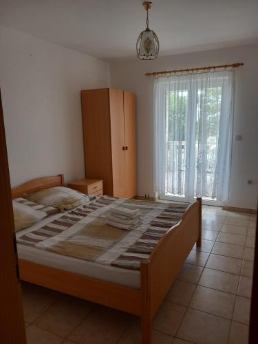 a large bed in a bedroom with a large window at Put Kandelica 86 in Privlaka