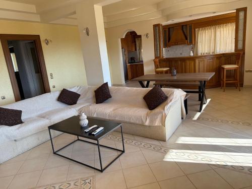 a living room with a couch and a table at iLIONI-Corfu Luxe Living-Modern 2BR,2BA,Close to the sea in Vátos