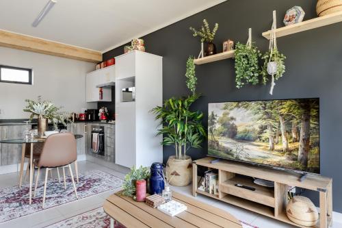 a living room with a tv and a table at Chawal Stays Green Valley 1 in Nelspruit