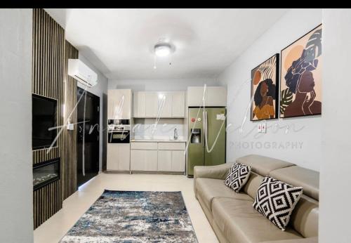 a living room with a couch and a kitchen at Sea Luxury Villa, Montego Bay Jamaica in Montego Bay