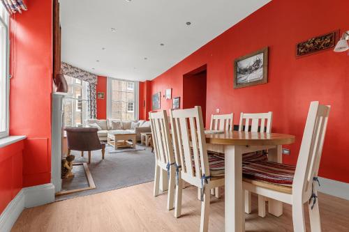 a dining room with red walls and a table and chairs at The Kings Apt 3 In The Heart Of York - Central Location in York