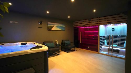 a bathroom with a jacuzzi tub with two chairs at Villa Sanys Selce in Selce