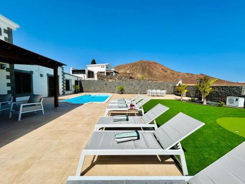 una fila de tumbonas en un patio en Villa Ocean Lanzarote, en Playa Blanca