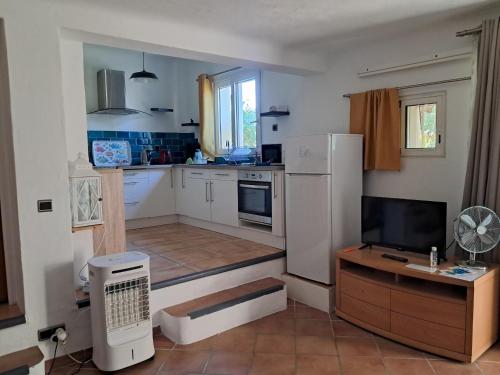 a kitchen with a white refrigerator and a tv at Chez Marie in Carry-le-Rouet