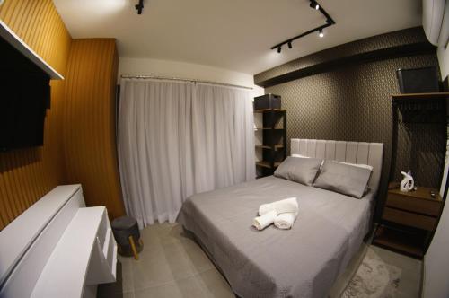 a bedroom with a bed with two towels on it at Studio Aconchegante in Sao Paulo