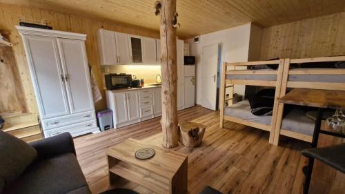 a room with two bunk beds and a table at Chata Veverka in Doksy