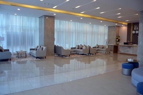 a lobby with couches and chairs in a building at The Lodge Suites in Manama