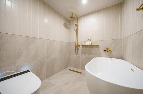 a bathroom with a white toilet and a sink at Munhyeon Signature Denbasta Hotel in Busan