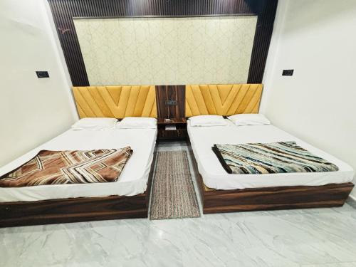 two beds sitting next to each other in a room at Kanak Bihari Yatri Niwas, 100 Meter Ram Ki Paidi, Saryu River in Ayodhya
