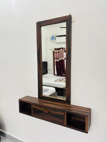 a mirror with a wooden frame on a wall at Kanak Bihari Yatri Niwas, 100 Meter Ram Ki Paidi, Saryu River in Ayodhya