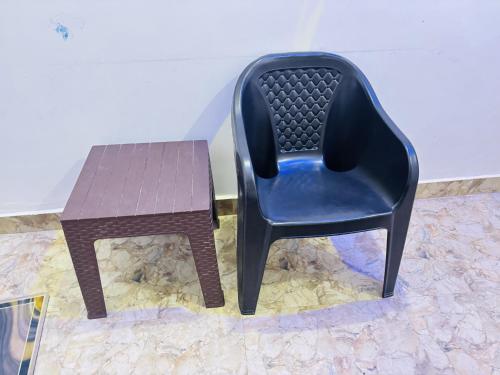 a plastic chair and a table on a floor at Kanak Bihari Yatri Niwas, 100 Meter Ram Ki Paidi, Saryu River in Ayodhya