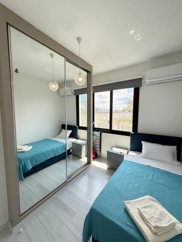 a bedroom with two beds and a large mirror at Yenikent's Diamond in Nicosia