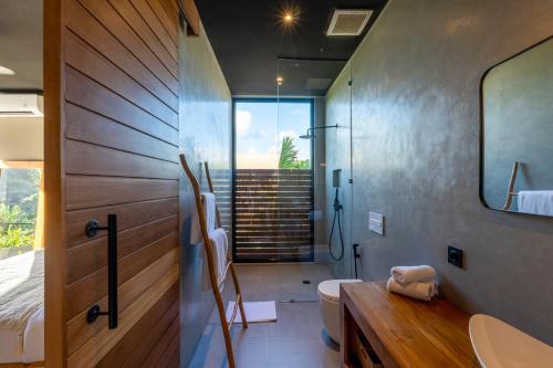 a bathroom with a shower and a toilet and a sink at Aloha Villas - Modern villas with private pool and lush gardens in Kuta Lombok