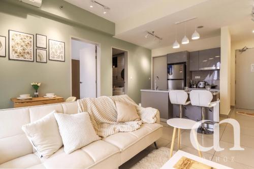 a living room with a white couch and a kitchen at Trion KL Residence by Dehoz Suites in Kuala Lumpur