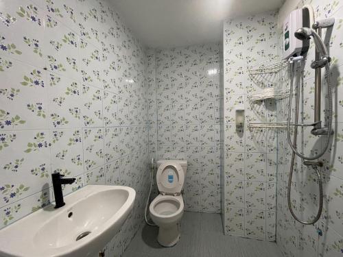 Un baño con lavabo, inodoro y ducha. en Pathomporn Fancy House, en Ban Rong O