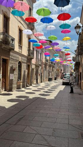 a bunch of colorful umbrellas hanging over a street at Domos La Corte Ghibellina in Iglesias