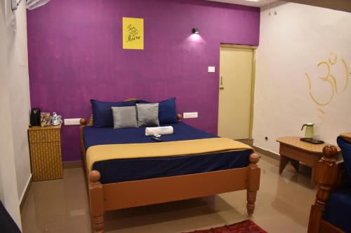 a bedroom with a bed with a purple wall at Aishwaryam home stay in Madurai