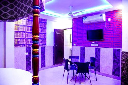 Una habitación con una mesa y sillas y un televisor. en D Season Hotel, en Agra
