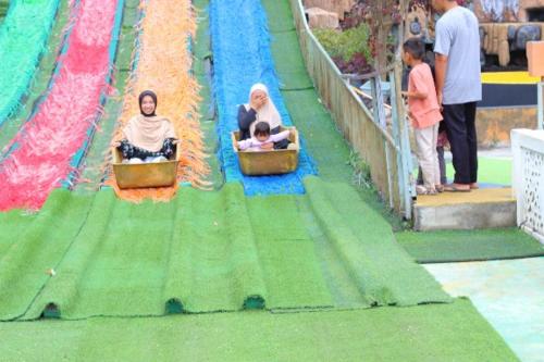 two women and a child riding on a roller coaster at villa taman surga rinjani in Sembalun Lawang