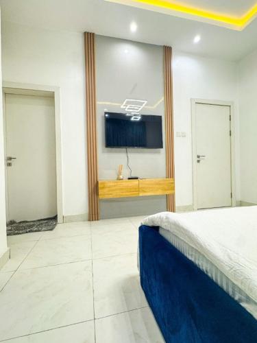a bedroom with a bed and a flat screen tv at Executive 2 bedroom apartment in Lagos