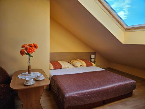 a bedroom with a bed and a table with a vase of flowers at Pokoje gościnne Klaudia in Międzywodzie