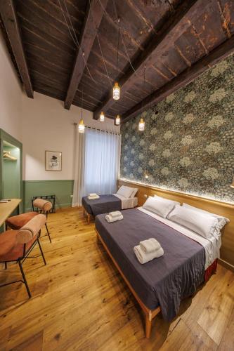 a bedroom with two beds and a table and chairs at The Tribunali Apartments By HouseinNaples in Naples