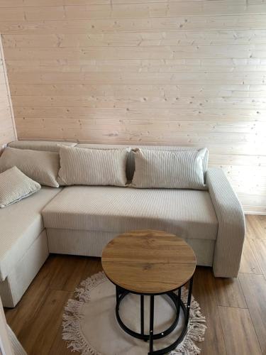 a living room with a couch and a table at Leśne Zacisze in Szewnia