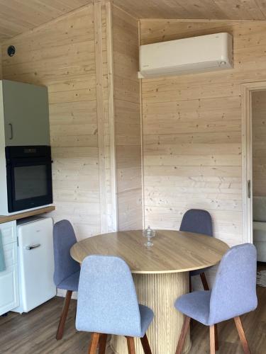a dining room with a wooden table and chairs at Leśne Zacisze in Szewnia