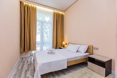a bedroom with a bed and a large window at Шикарная Двушка в самом центре Алматы #12 in Almaty