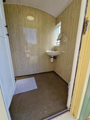 a small bathroom with a sink and a mirror at Park Farm Holidays Glamping in Lyndhurst