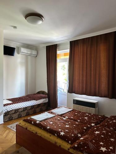 a bedroom with two beds and a window at Birta Apartman in Hajdúszoboszló