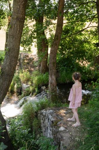 a little girl standing on a rock near a river at Chaty ForRest in Valča