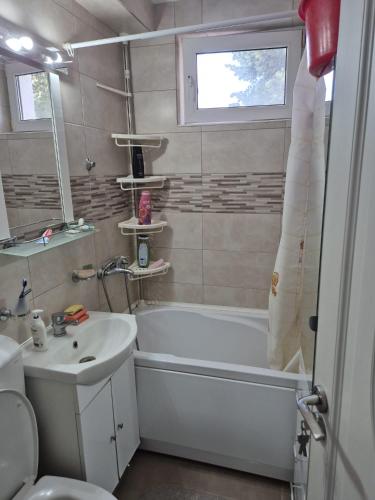 a bathroom with a white tub and a sink at Tulcea Soft Apartment in Tulcea