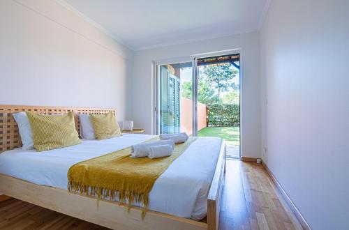 ein Schlafzimmer mit einem großen Bett und einem großen Fenster in der Unterkunft Aroeira - Nature, Beach & Golf, by TimeCooler in Almada