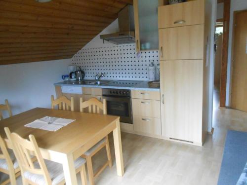een keuken met een houten tafel en een tafel en stoelen bij Ferienwohnung Jutta in Höchst