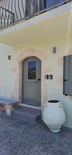 a door of a building with a vase next to it at Villa Quercus in Alikampos