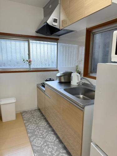 a small kitchen with a sink and a refrigerator at 花の宿 in Osaka